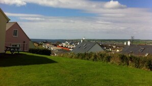 Un quartier résidentiel avec des maisons, une table de pique-nique et une vue dégagée sur la mer.