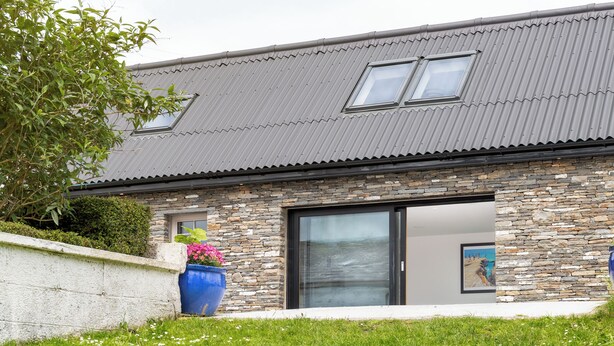 A modern house with a stone facade, large windows, and a grassy yard. - The Play School, The Play School (Miltown Malbay)