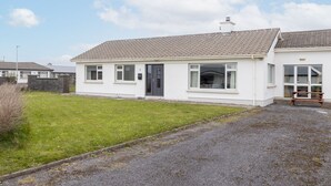 Een gelijkvloers huis met een pannendak, een voordeur en een klein portaal.