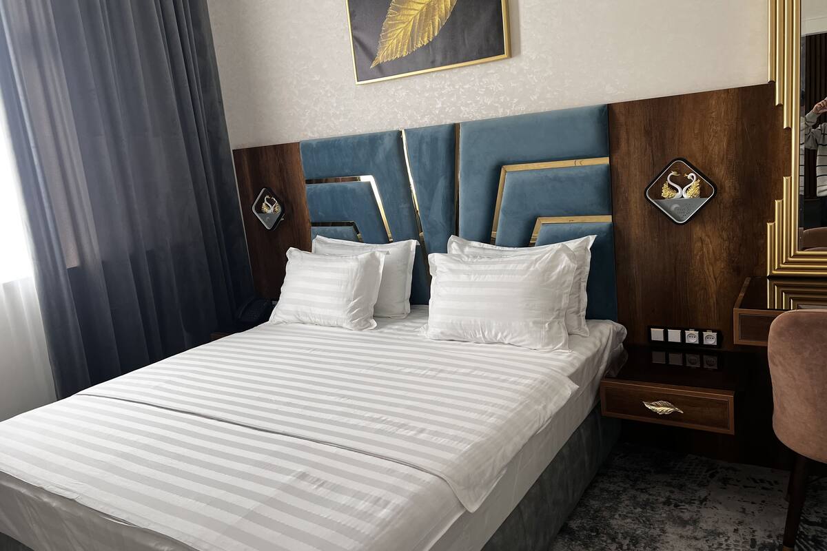 Premium tweepersoonskamer | Een minibar, een kluis op de kamer, een bureau, verduisterende gordijnen