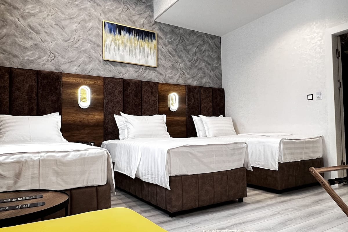 Deluxe driepersoonskamer | Een minibar, een kluis op de kamer, een bureau, verduisterende gordijnen