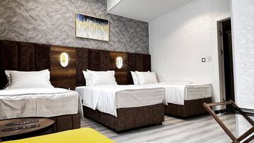 Deluxe Triple Room | Minibar, in-room safe, desk, blackout drapes