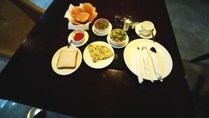 Une table à manger avec différents plats, notamment du pain, une part de pizza et un bol de soupe.