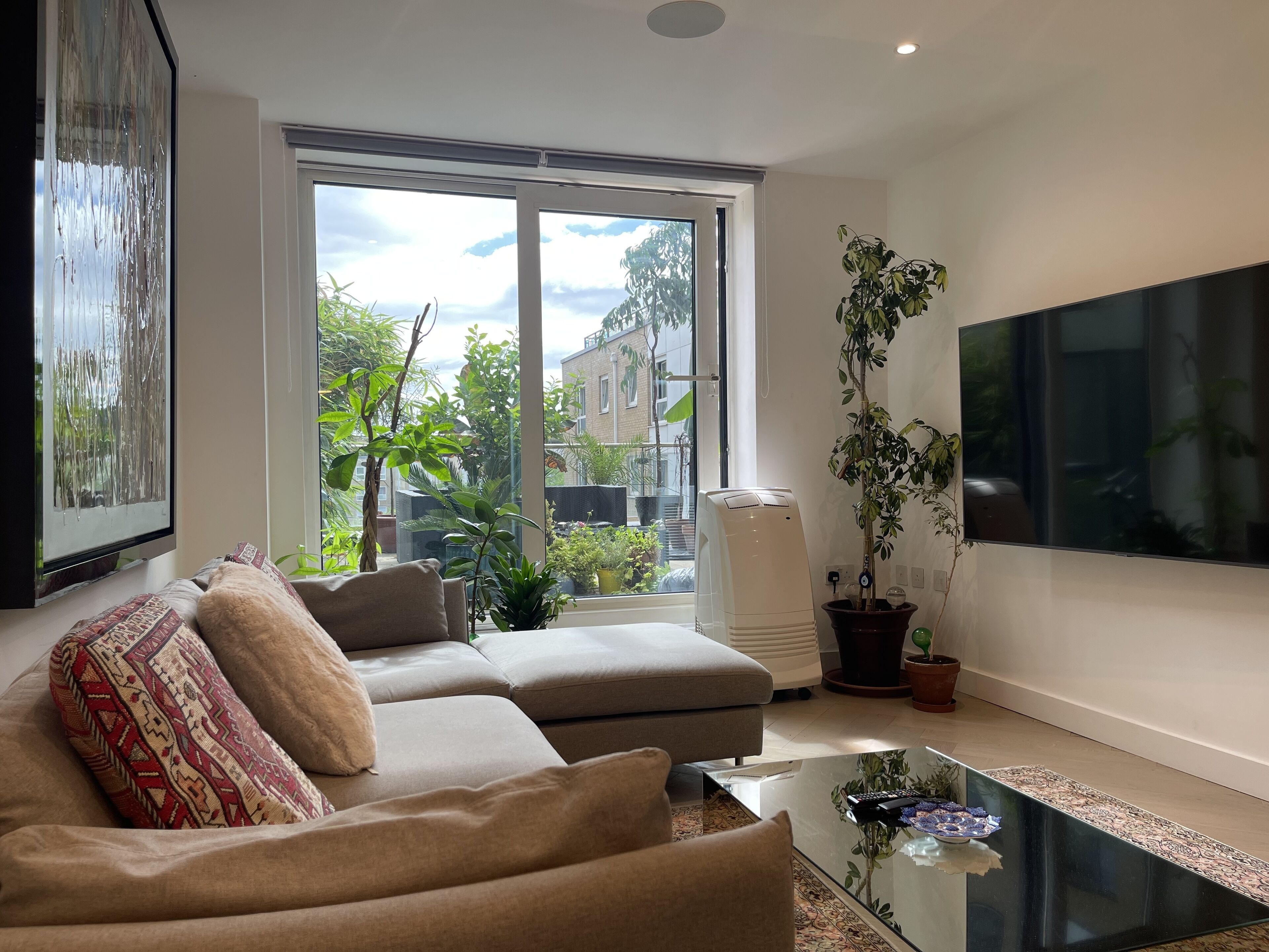 A modern living room with a sofa, a coffee table, and a large TV.