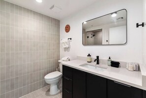 Une salle de bain moderne avec des toilettes, un lavabo et un miroir.