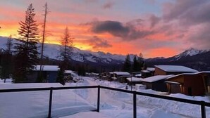 A snowy mountain landscape with a sunset. - Luxury 4 BDR Home / Hot tub / Amazing Fireplace! (Fernie)