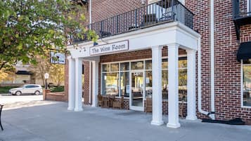 A brick building with a balcony and a sign reading "The Wine Room."