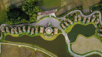 Vista aérea de una zona residencial con casas, una plaza circular central y cuerpos de agua circundantes.