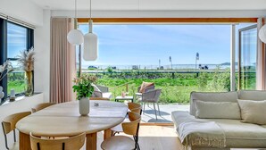 A modern living room with a large window overlooking a scenic view. - Gorgeous apartment in Kerteminde (Kerteminde)