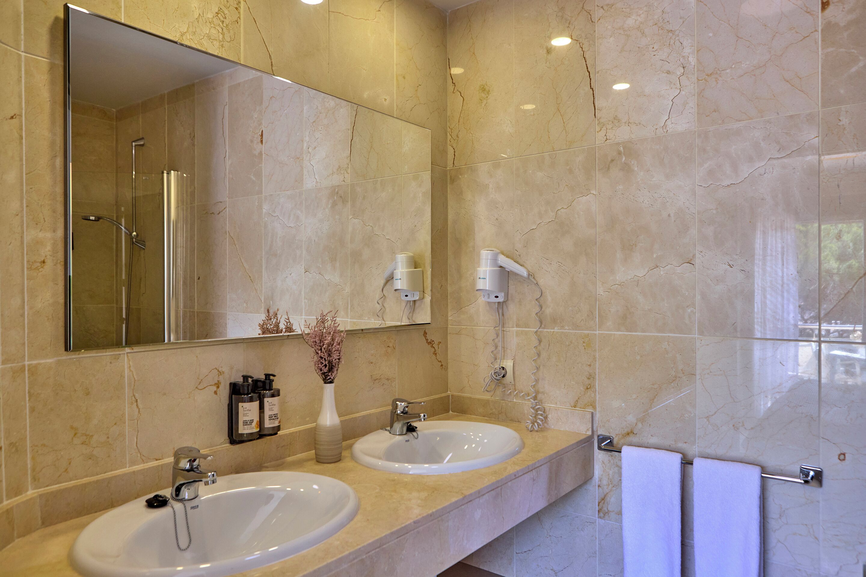 Un bagno con due lavandini, uno specchio grande e una doccia.