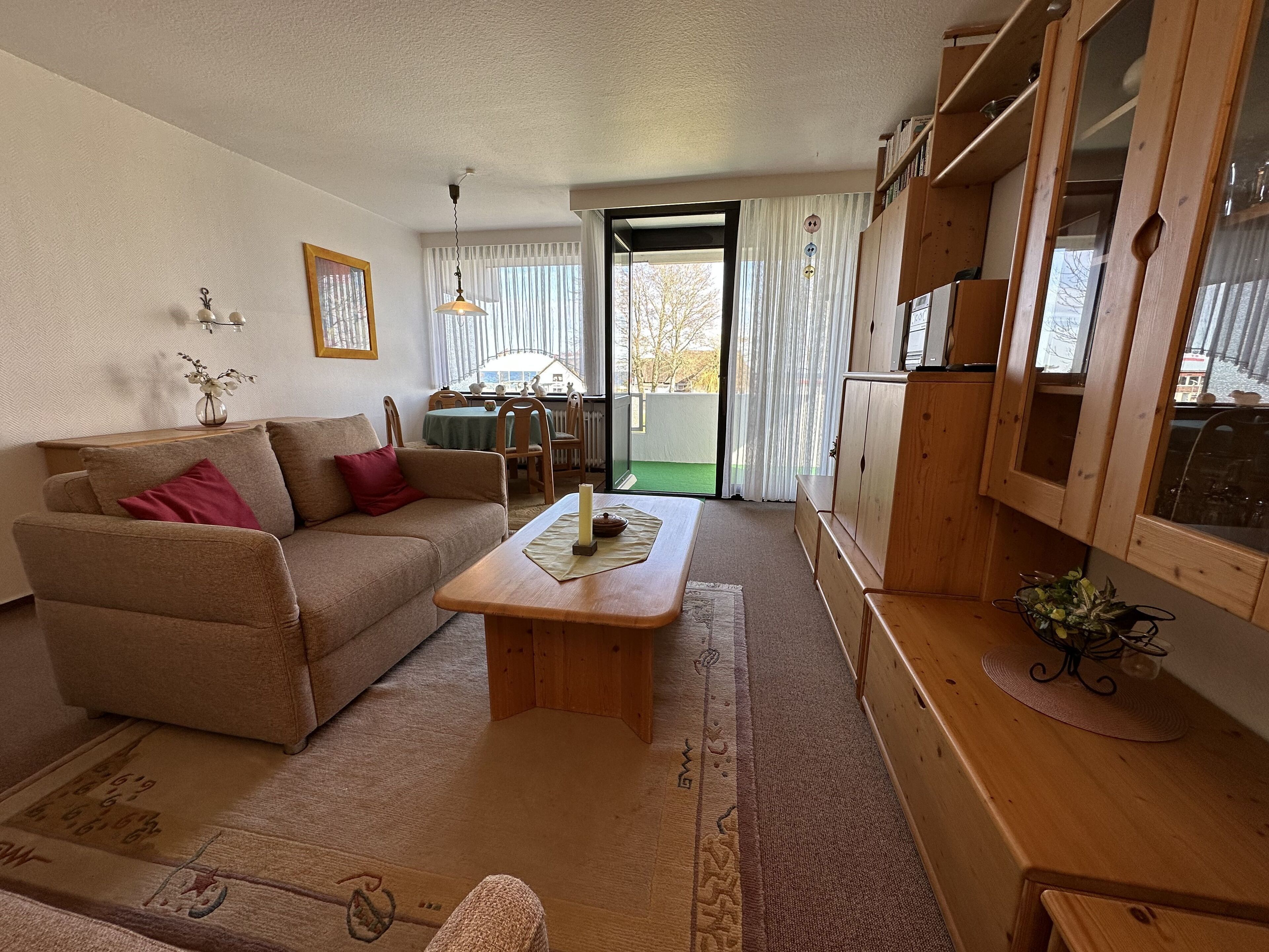 Una sala de estar acogedora con un sofá, una mesa de centro de madera y una zona de comedor con una mesa y sillas.