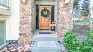 A stone house entrance with a wooden door, a welcome sign, and a wreath. - Private Hot Tub. Steps to The Lift. Beautiful Home (Breckenridge)