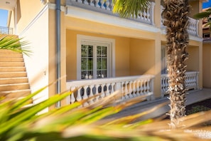 A two-story building with a balcony, a palm tree, and a staircase. - Premium Apartment Hari I (Porec)
