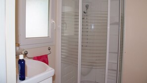 A bathroom with a white sink, a red towel, and a glass shower enclosure. - Camping Tikayan Les Palmiers (Hyères)