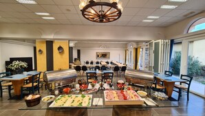 Un buffet proposant une grande variété de plats et agrémenté d’un imposant lustre.