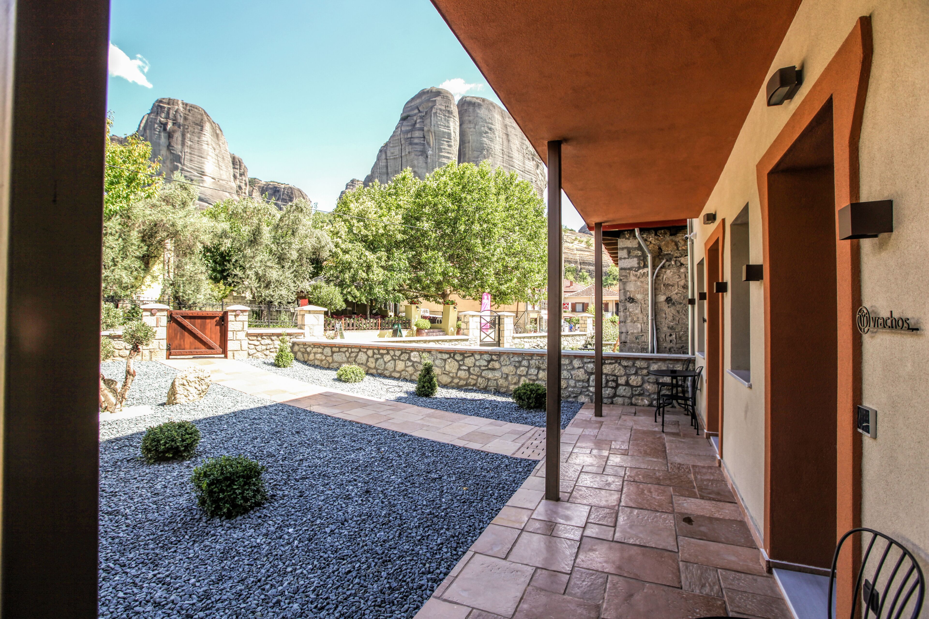 A hotel corridor with stone walls, a covered patio, and a view of mountain peaks.