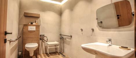 Un baño moderno con inodoro, lavamanos y ducha.