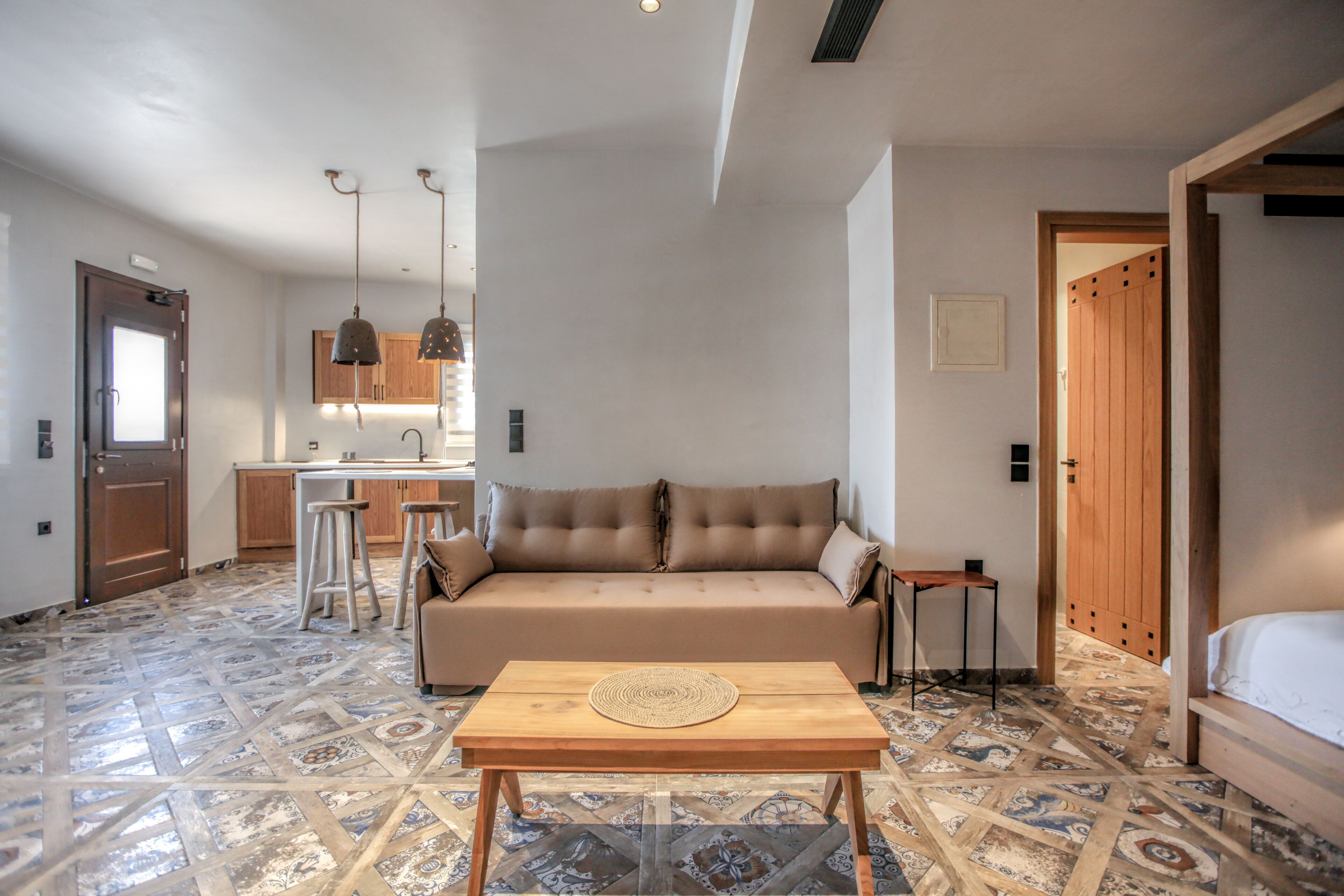 Un espace de vie compact comprenant un canapé, une table basse, un coin cuisine et une salle de bain.