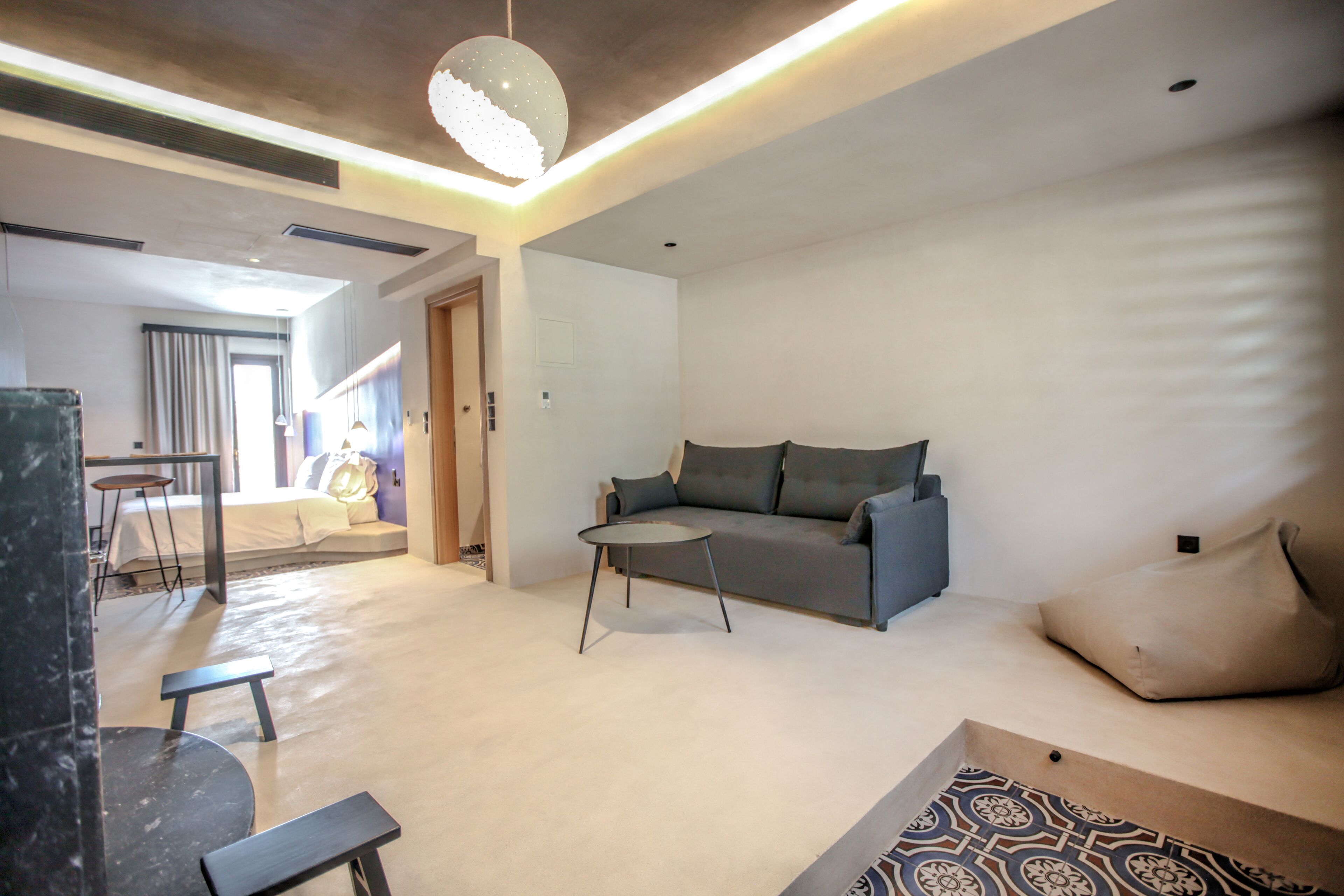A modern living room with a grey sofa, a round coffee table, and a patterned rug.