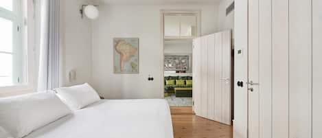 A bedroom with a large bed, a wardrobe, and a map on the wall.