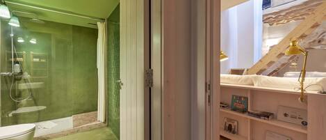A modern bathroom with a glass-enclosed shower, a white toilet, and a wooden floor.