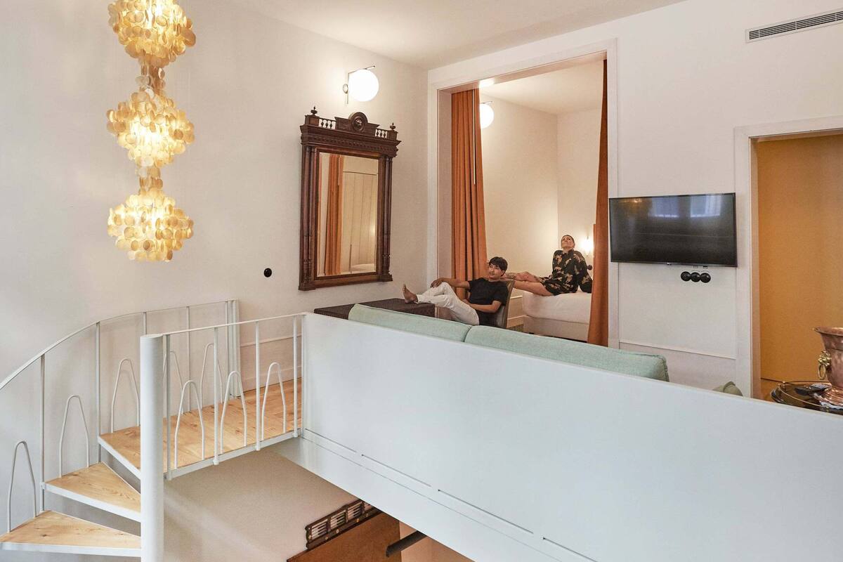Un espacio habitable en varios niveles con mesa de billar, una escalera y un área de estar.