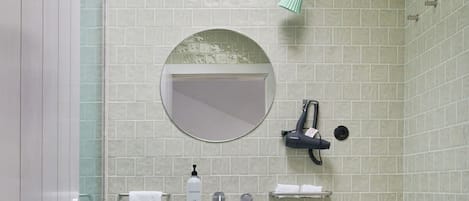 A bathroom with a sink, mirror, towel rack, and a small table.