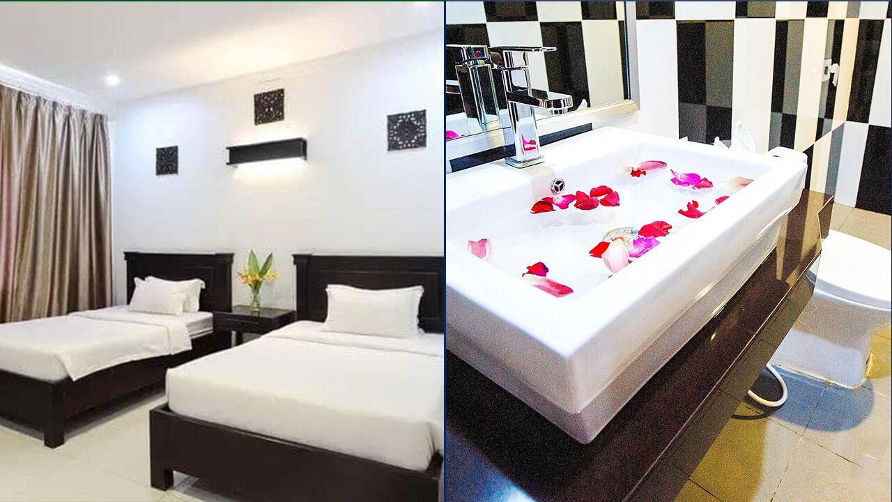 A hotel room with two beds, a bathroom with a large bathtub, and a checkered wall design.
