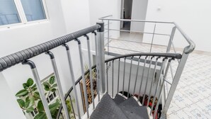 Una escalera con barandillas de metal y piso de baldosas.