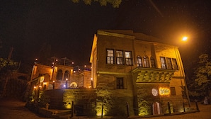 A historic building with a stone facade, multiple windows, and a clock on the front wall.
