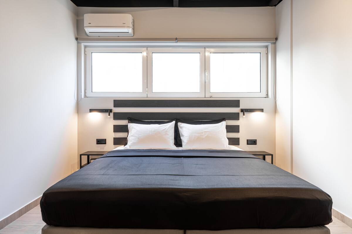 Une chambre à coucher avec un lit, une fenêtre et un appareil de climatisation.