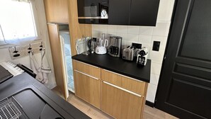 Una cocina compacta con electrodomésticos modernos, como cafetera, tostadora y licuadora.