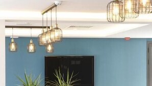 A dining area with tables set for a meal, chairs, hanging light fixtures, and potted plants. - Maia Hotel Suites (Tunis)