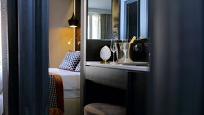 Ein Hotelzimmer mit einem Bett, einem Nachttisch mit Lampe, einem Spiegel und einem fenster mit Vorhängen.