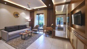 A modern living room with a sofa, armchairs, a coffee table, and a TV. - Arova Woods Zinc Journey by The Fern (Mawal)
