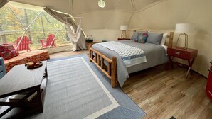 A tented accommodation room with a bed, bedside tables, a desk, and a view of the outdoors. - Seasonal, Cozy Geo-Dome with Heat/AC on Private Hiking paradise in Gunks. (Wallkill)