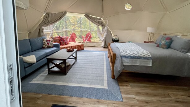A tented accommodation with a sofa, a bed, and a small table. - Seasonal, Cozy Geo-Dome with Heat/AC on Private Hiking paradise in Gunks. (Wallkill)