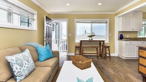 Una sala de estar con un sofá color beige, una mesa de centro blanca y una cesta de mimbre.