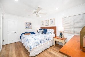 A bedroom with a bed, a nightstand, a ceiling fan, and a window with blinds. - Oceanfront 3 Bed 3 Bath Duplex on 60th St (Newport Beach)