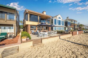 A beachfront property with a patio area, outdoor seating, and a barbecue grill. - Oceanfront 3 Bed 3 Bath Duplex on 60th St (Newport Beach)