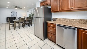 Una cocina moderna con electrodomésticos de acero inoxidable, armarios de madera y encimera de granito.