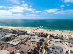 A coastal residential area with a beachfront, houses, and a stop sign. - 6 Bedroom home located 2 houses in from the Beach (Newport Beach)