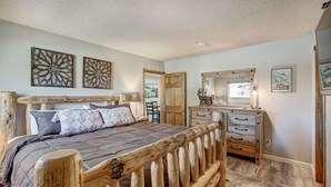 A bedroom with a wooden bed frame, a dresser, and a mirror.