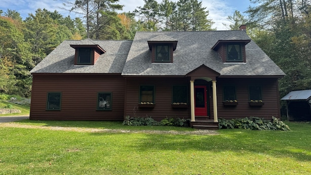 A two-story house with a red door, a small porch, and a well-maintained lawn. - Edgewood, Beautiful custom built 5 bdrm home w/ fire pit, game room, scenic pond (Milford)