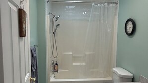 A bathroom with a shower, toilet, sink, and a clock on the wall. - Grandview Private 2 room suite, 5 minutes to Dreams Park, close to town (Milford)