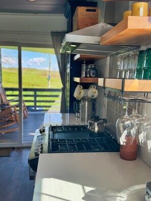 Uma cozinha moderna com fogão a gás, armários de madeira e vista para o exterior.