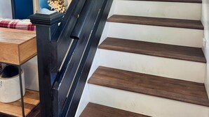 A staircase with wooden steps and a black handrail. - Grousehall Total Renovation, contemporary design, short drive to Cooperstown (Schuyler Lake)