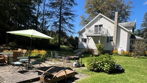 A two-story house with a balcony, a patio with outdoor furniture, and a well-maintained lawn. - Hemlock - Quiet neighborhood, fire pit, large backyard, near All Star Village (Oneonta)