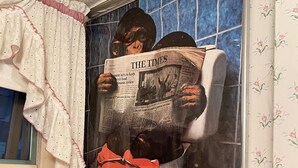 Un baño con inodoro, una ventana con cortina y un muro con azulejos.