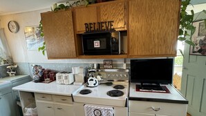 Una cocina con gabinetes de madera, un microondas, una estufa y un tostador.